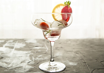 cocktail made from Strawberries and rosemary ice cubes into the glass