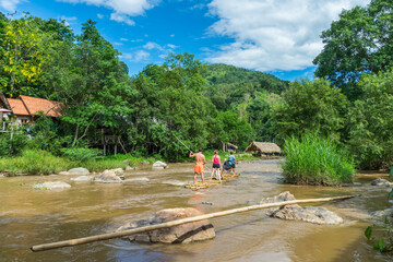 travel / Tourist trying out traditional bamboo raft at thailand.