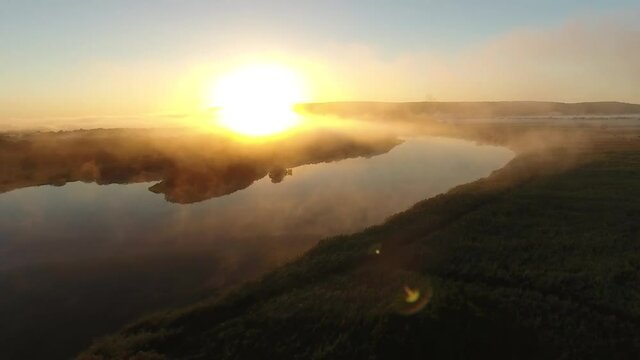 Low flight river valley bent early morning fog clouds Primorye, Vladivostok. Yellow orange sunrise horizon. Wide open space Aerial drone beautiful Russian nature landscape. Romantic cinematic mood.