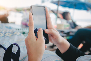 Young business woman working with modern devices on the beach, using mobile phone.