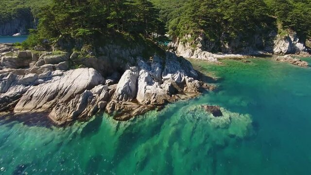 Island Languishing Heart close blue water. Far East Marine Biosphere Reserve, Primorsky Krai Vladivostok Russia. Unique National park Japan Sea ocean. Aerial Helicopter Drone flight forward. 4k