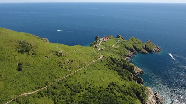Helicopter drift flight around Famous Lighthouse on Gamov peninsula. Far East Marine Reserve Primorsky Krai Vladivostok Russia. Unique National park Japan Sea ocean. Colorful summer day. 4k