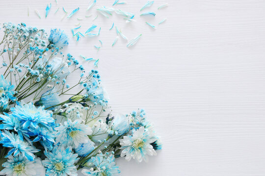 Fototapeta beautiful and delicate blue flowers arrangement on white wooden background
