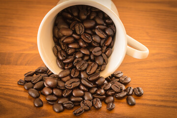 Spilled coffee beans from the white cup.
