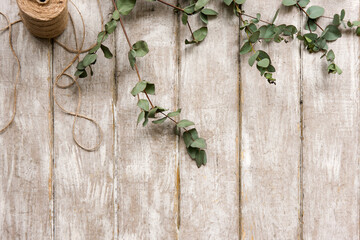 Laurel decor on wood background top view. Floristry workshop table. Decorative artwork from spring flower