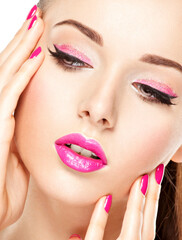  face of a beautiful  girl with pink eye makeup, lips and bright pink  nails.