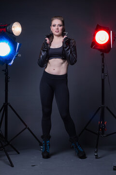 Girl in a leather jacket on stage and colored spotlights