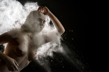 Girl topless in a cloud of white dust studio portrait