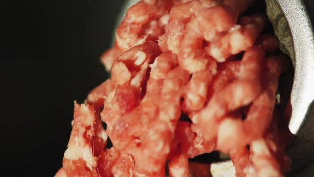 Action of mincer machine with fresh chopped meat. Close-up
