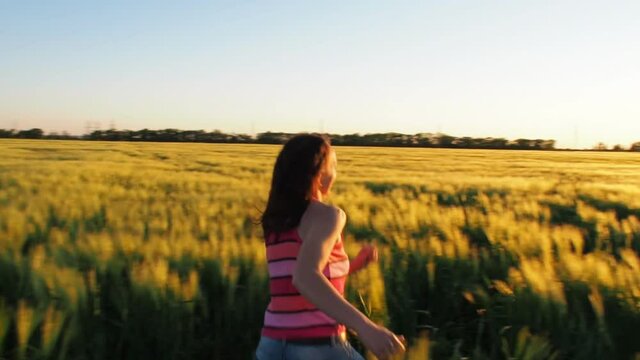Girl in a wheat field at sunset. Sunset over the wheat.