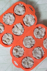 The process of making bread from rye flour with seeds. Bright orange silicone mold for cupcakes. Top view.