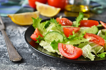 Vegetable salad with cucumber, tomatoes and olive oil on a concrete background