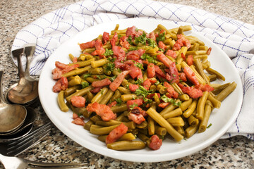 green beans with fried bacon and freshly chopped parsley on a plate