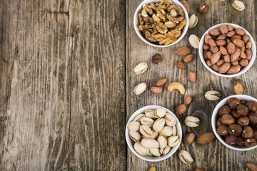 Fototapeta premium Nuts in a plate on a wooden table.