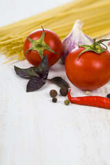 Raw pasta and spices in wooden table.