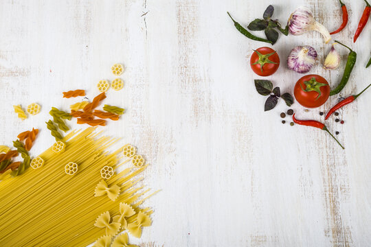 Raw pasta and spices in wooden table.
