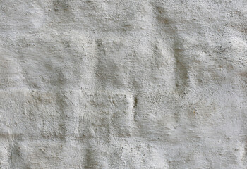 Ancient white brick wall with a thick layer of plaster