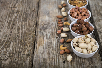 Nuts in a plate on a  wooden table.