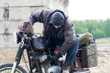 A post apocalyptic man on motorcycle near the destroyed building