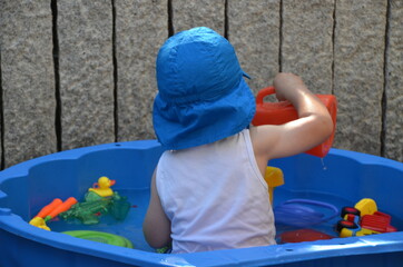 Kleinkind in Planschbecken mit Spielzeug
