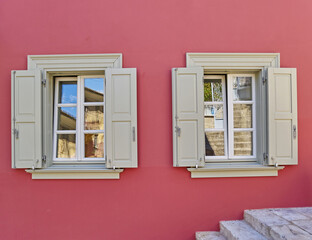 two grey windows on colorful fuchsia house wall