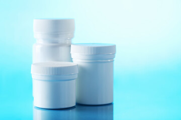 White cosmetic bottles on a blue background