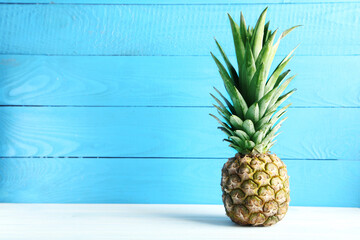 Ripe pineapple on a white wooden table