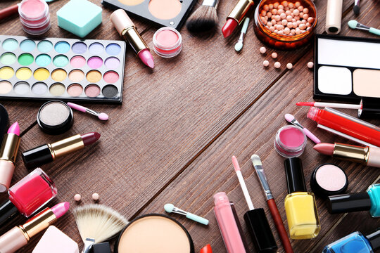 Different makeup cosmetics on brown wooden table
