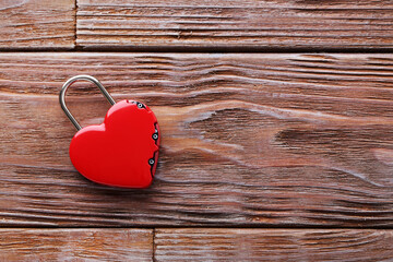Heart shaped padlock on brown wooden table