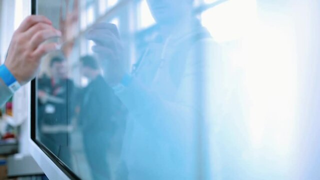 The man uses a large touch screen