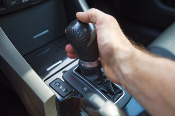A man's hand on an automatic gearbox. Automatic shift transmission.
