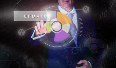 A businessman selecting a Update button on a computerised display screen.