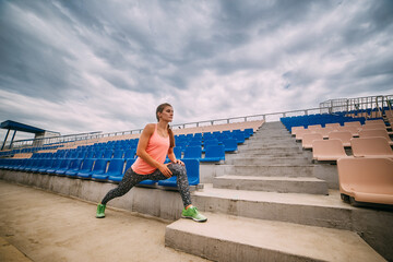 Beautiful muscular girl running around the stairs at the stadium. Crossfit, fitness, healthy lifestyle