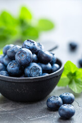 Fresh Blueberries in a bowl on dark background, top view. Juicy wild forest berries, bilberries. Healthy eating or nutrition.