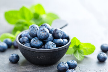 Fresh Blueberries in a bowl on dark background, top view. Juicy wild forest berries, bilberries. Healthy eating or nutrition.
