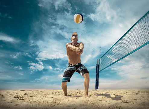 Beach volleyball player in action at sunny day under blue sky.