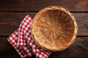 Empty wicker basket on a wooden background, top view