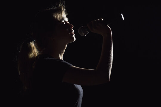 portrait of woman singing into microphone