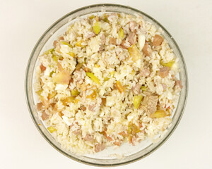 Simple rice salad in a transparent bowl on white background - top view