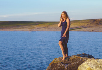 Beautiful young girl at sunset against the sea