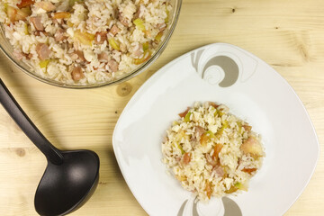 Simple rice salad in a transparent bowl on wooden background - top view