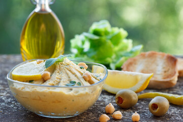 Homemade Chickpea Hummus in Rustic Bowl with Olive Oil and lemon. Arab traditional food.