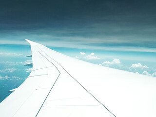 Fototapeta na wymiar Wing of the plane, Looking through window aircraft during flight in wing with a nice blue sky