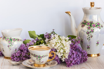 beautiful spring table setting for coffee break with lilac flowers on wooden table