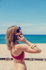 Girl talking on the phone on the sea / ocean beach.