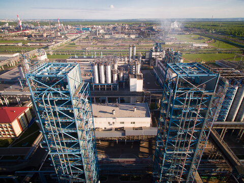 Two large distillation tower at the refinery on the backdrop of the industrial landscape. Aerial view
