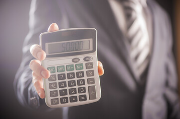 Cropped image of a businessman showing calculator