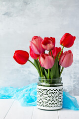 Background to the mother's day or birthday. Beautiful fresh pink and red tulips flowers in a vase. Copy space.