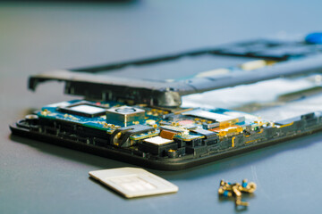 Disassembled mobile phone in the service center with internal components of the camera and speaker