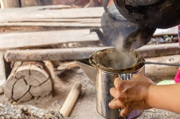 hand make a cup of coffee with bag in stainless steel pot, traditional coffee, selective focus